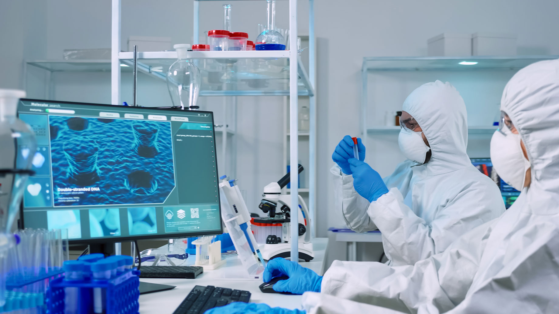 chemist-doctor-ppe-suit-working-pc-while-lab-technician-using-microscope-team-scientists-examining-vaccine-evolution-with-high-tech-researching-treatment-against-covid19-virus